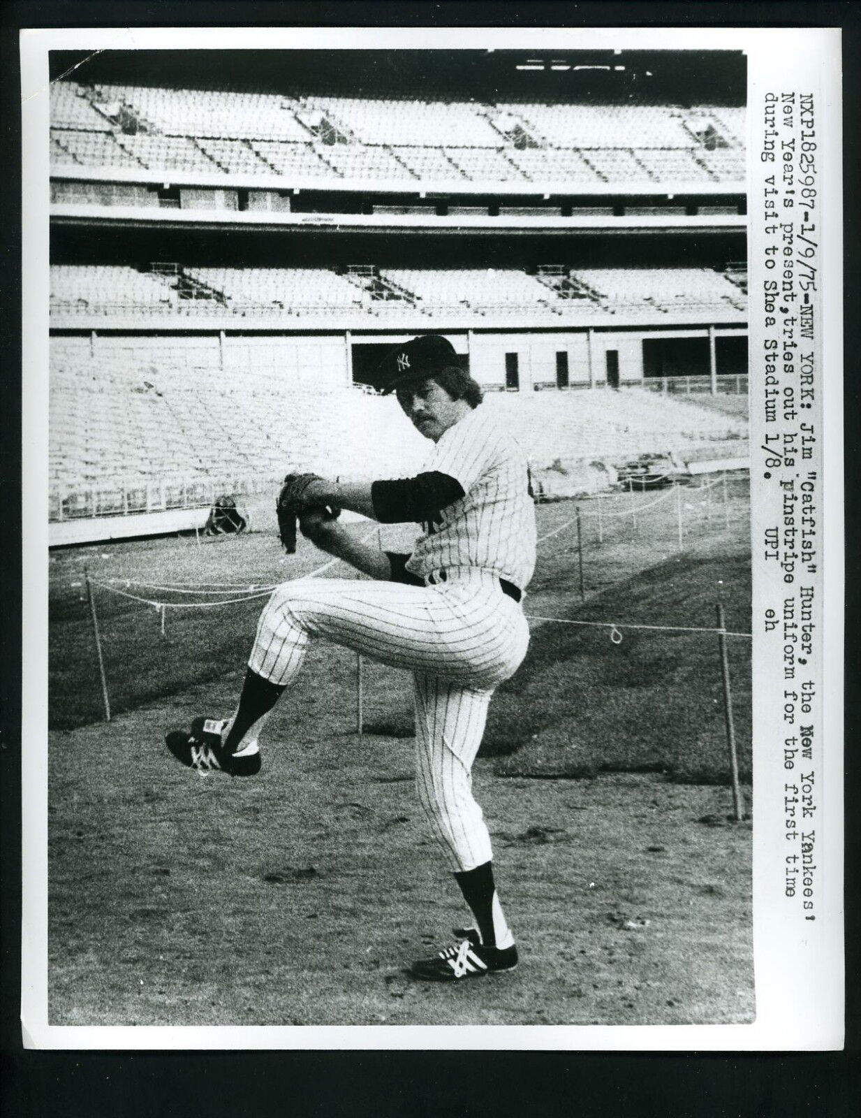 Jim Catfish Hunter puts New York Yankees uniform on first time 1975 Press Photo Poster painting