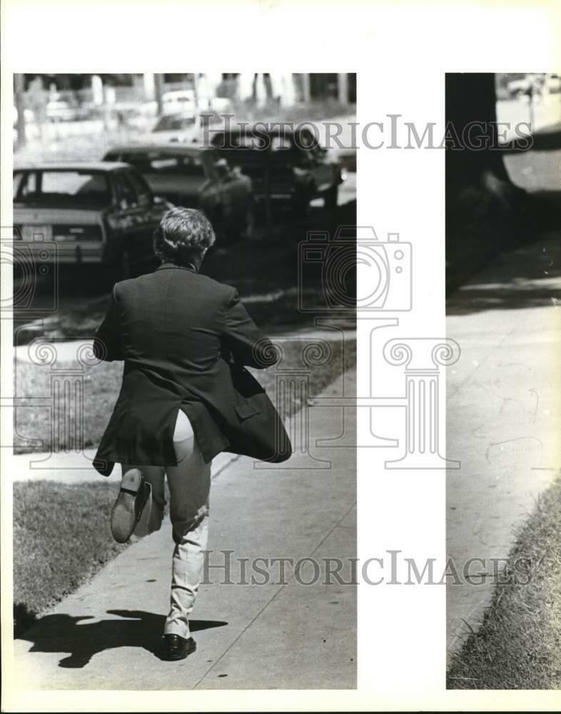 Press Photo Poster painting Man In Business Clothing Runs Down City Street - saa57946