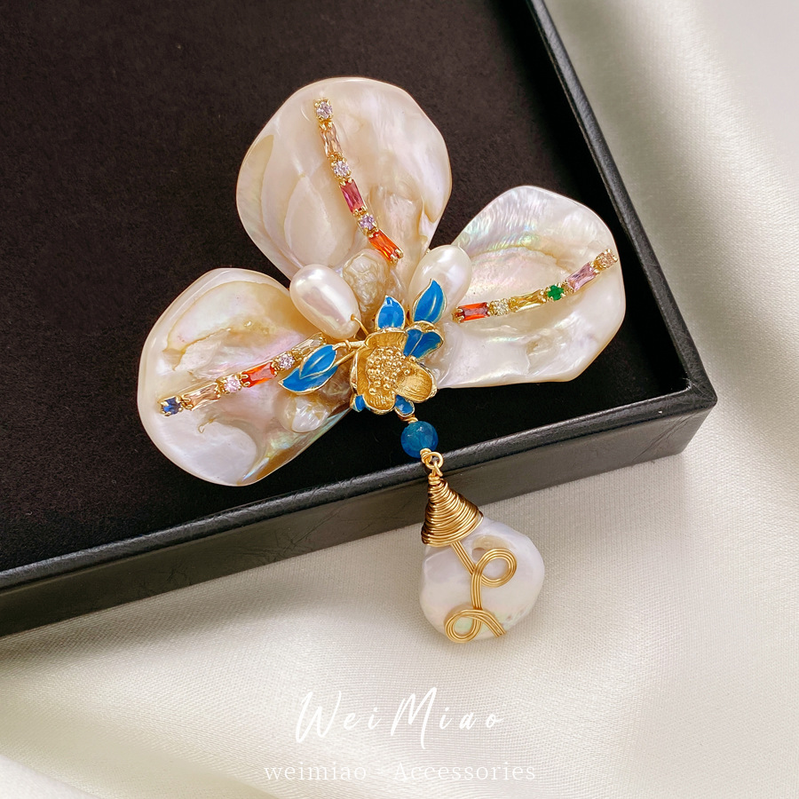 This gold-plated brooch with zircon freshwater droplet flower and pearl accents exudes a sophisticated understated luxury feel perfect for vintage-inspired clothing