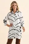 Front view of a woman wearing an olive green abstract print longline linen-blend shirt with buttons