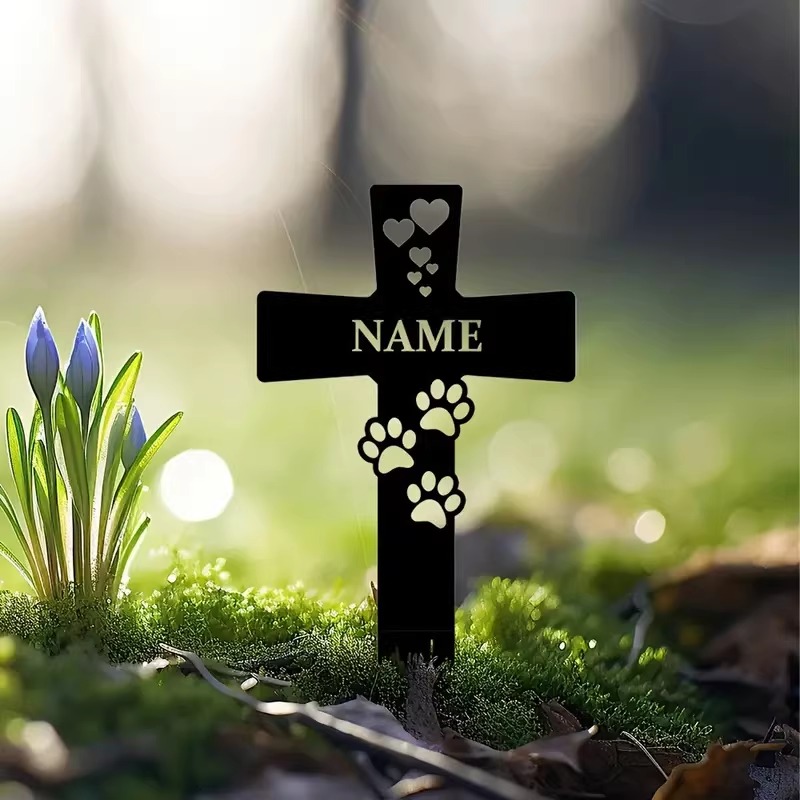 Pet cemetery garden stake surrounded by flowers and stones