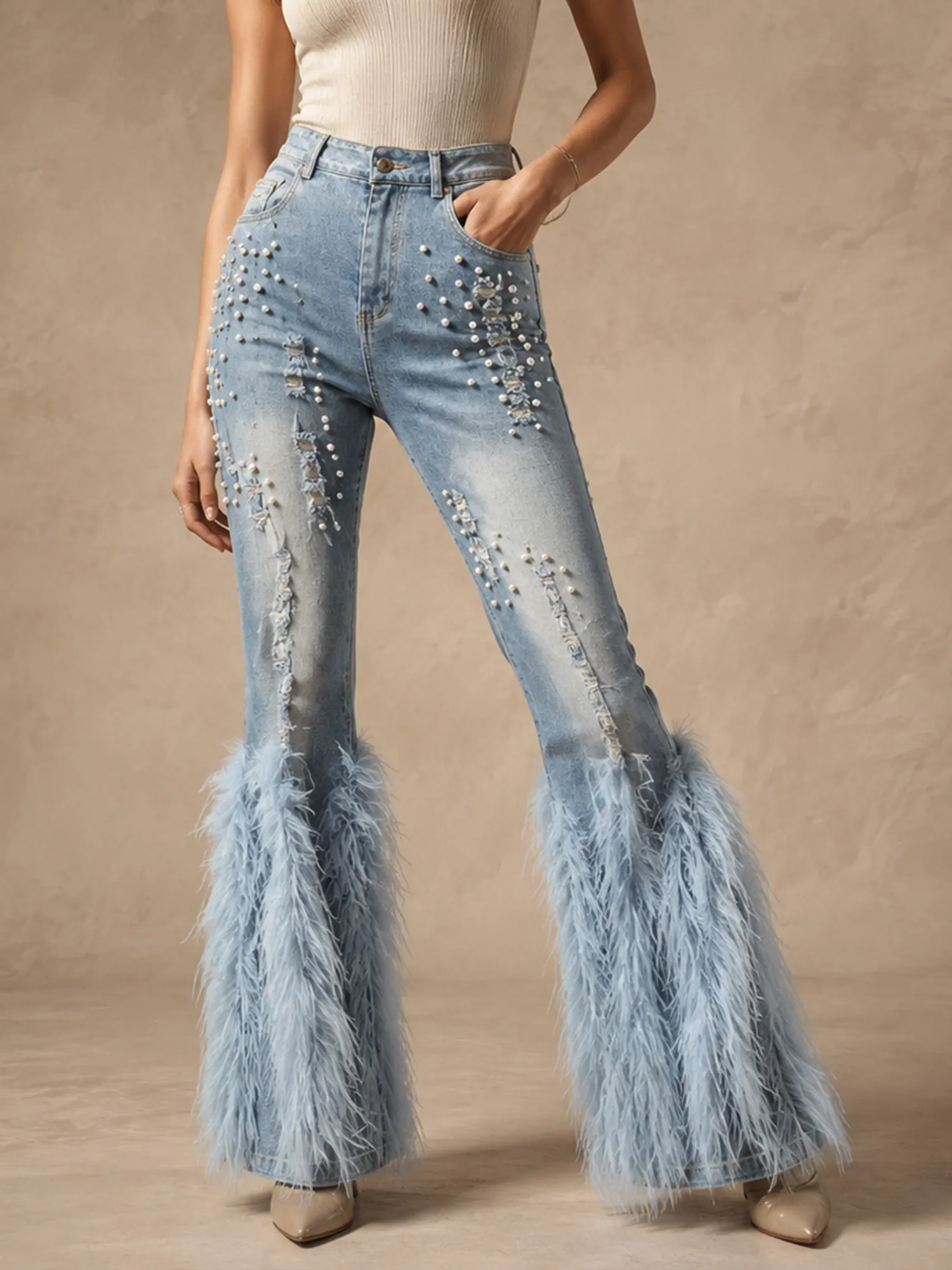 Perfect for country music festivals &mdash; Light wash blue beaded pearl heavy distressed faux feather flared jeans with soft stretch cuffs for women.