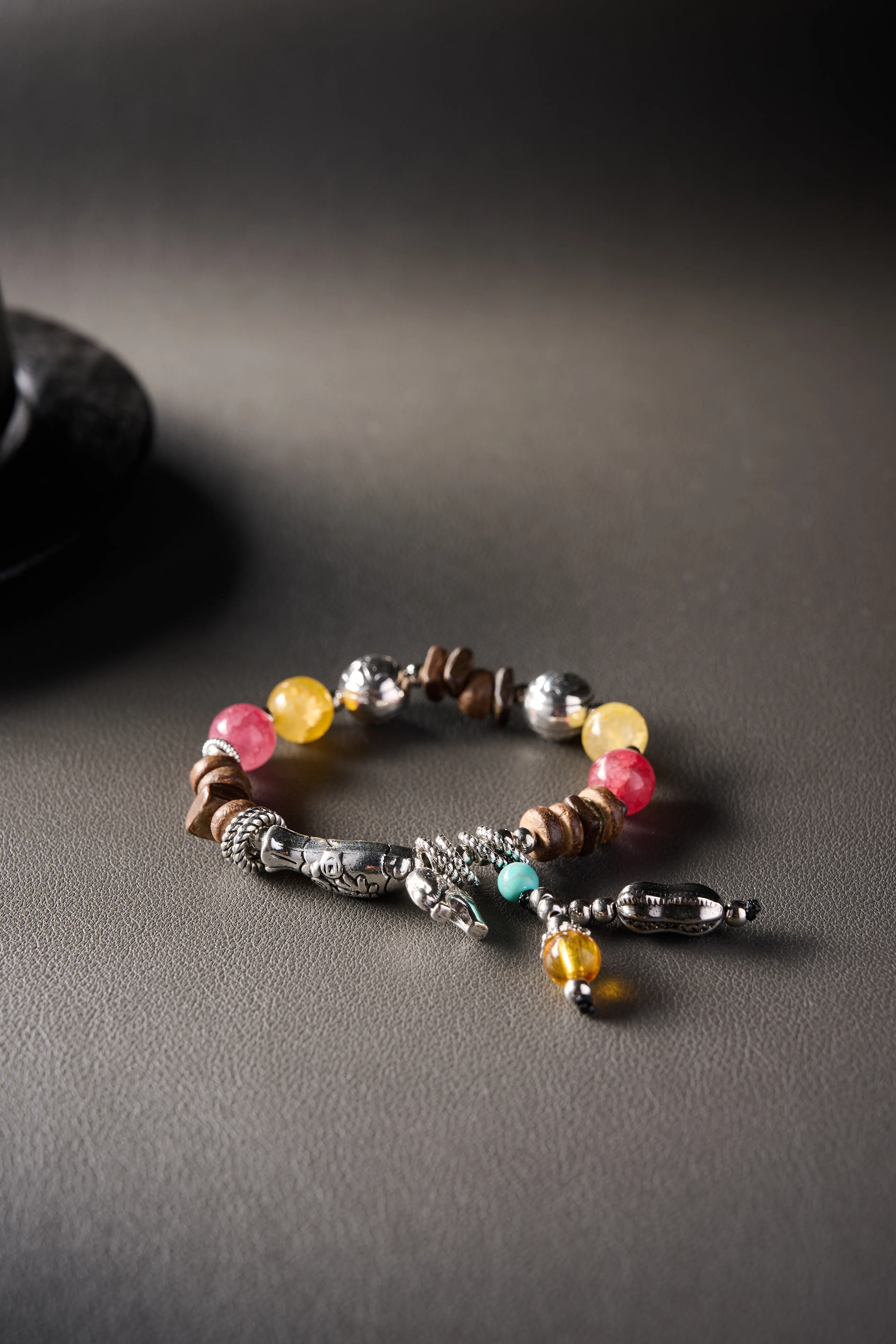 Detail – elephant alloy charm and braided knot centerpiece, handcrafted finish.