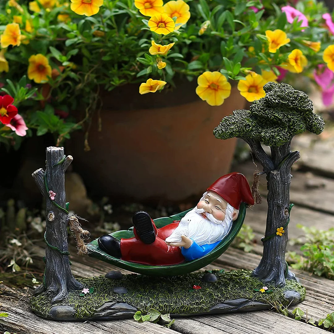 Garden Gnome Statue Lying In Hammock Hanging From Tree