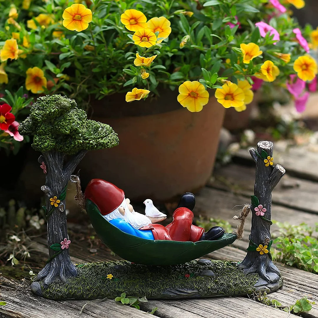 Garden Gnome Statue Lying In Hammock Hanging From Tree