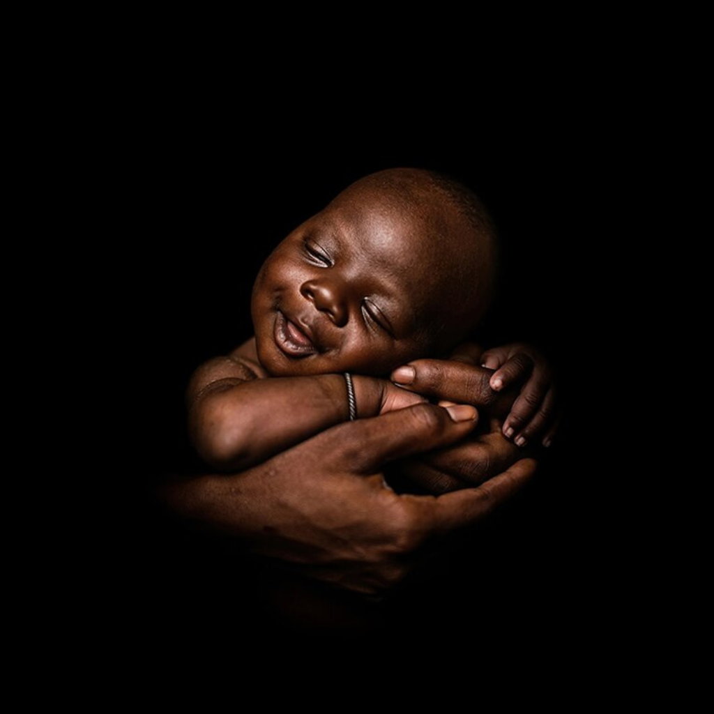 SLEEPING BABY ON HANDS CANVAS ART