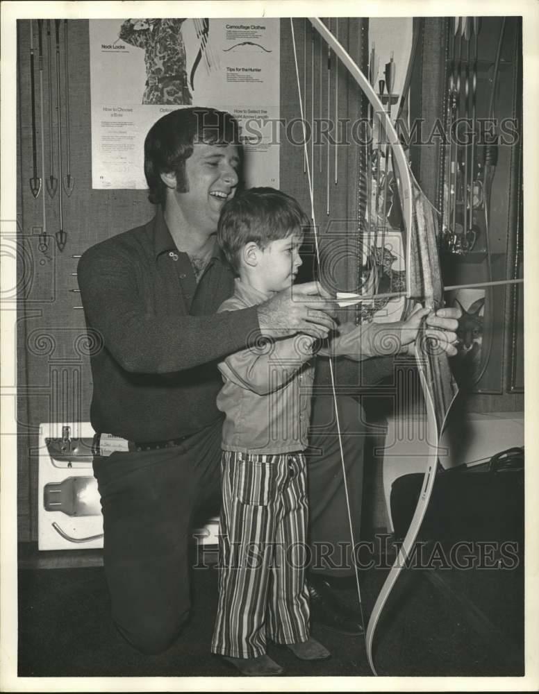 Press Photo Poster painting Archery Store's Brad Locker Teaches Boy to Use Bow & Arrow, Houston