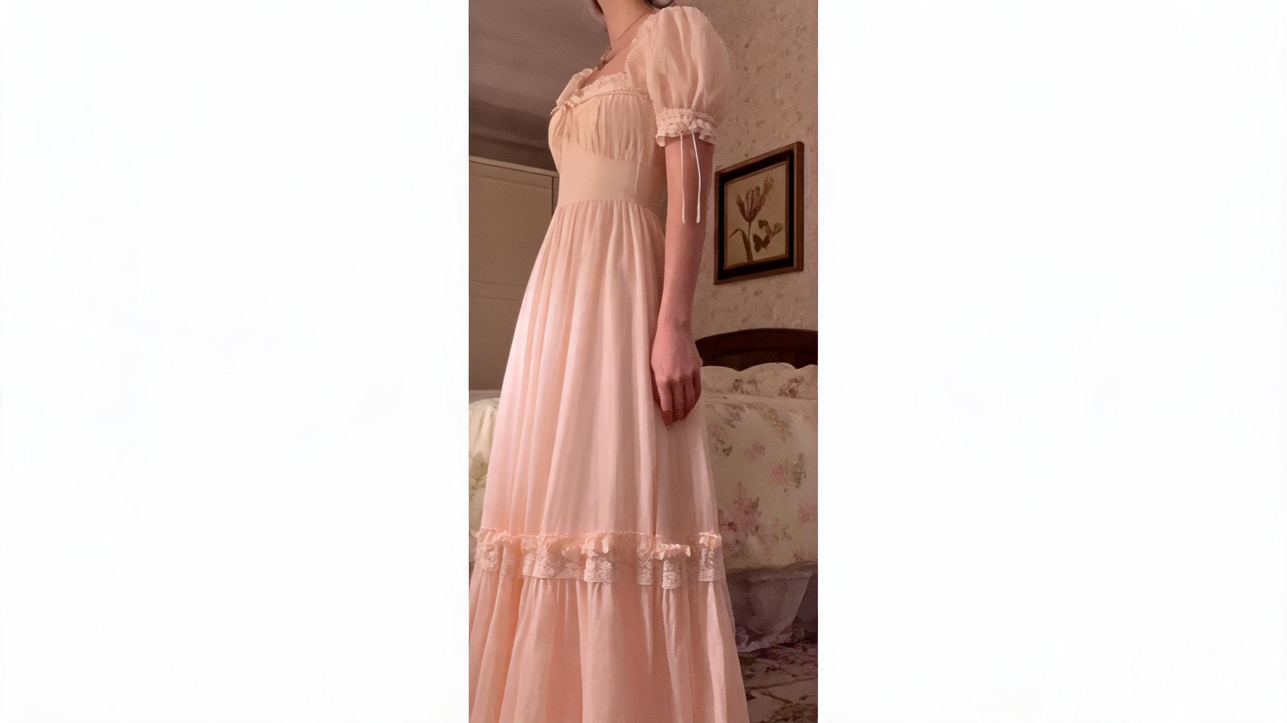 Detail of the square neckline with ivory lace trim, self-fabric bow at bust, and puff sleeve with ruffled lace cuff and ribbon ties