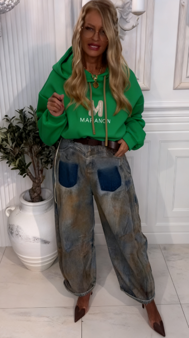Bluza z kapturem z wyjątkowym wzorem liter w połączeniu z luźnymi jeansami w kontrastujących kolorach.